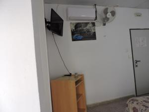 um quarto com uma cama e uma televisão na parede em Hospedaje Lisboa Algeciras em Algeciras