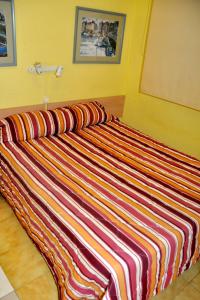 Łóżko lub łóżka w pokoju w obiekcie Hostal El Jardín