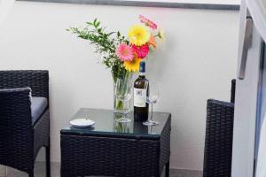 a bottle of wine and a vase of flowers on a table at Matteo's House B&b in Amalfi +32 photos