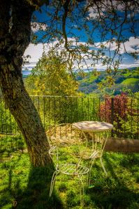 a table and chairs sitting next to a tree at Casa do Comediante in Cerdeira