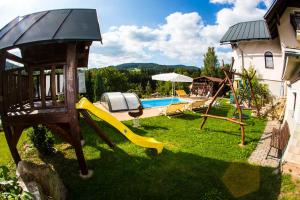 um quintal com um parque infantil com um escorrega e uma piscina em PRIVAT Pacholik em Rokytnice nad Jizerou