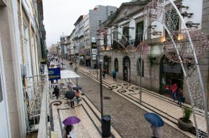 un gruppo di persone che camminano per strada con gli ombrelloni di Change The World Hostels - Porto - Santa Catarina a Porto