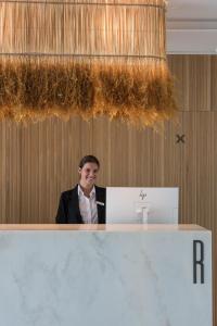 a man sitting at a counter in a room at Aroeira Lisbon Hotel - Sea & Golf in Aroeira