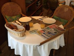 a table with a basket of food and glasses of orange juice at Hôtel Le Porquerollais in Porquerolles