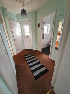 an empty hallway with a door and a rug at 2 Bedroom Rayleigh Apartment in Rayleigh