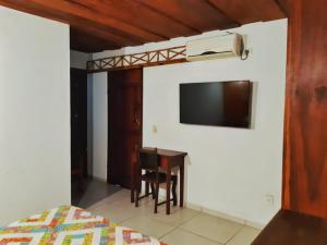 a bedroom with a desk and a television on a wall at Pousada Solar D Alcina in Paraty