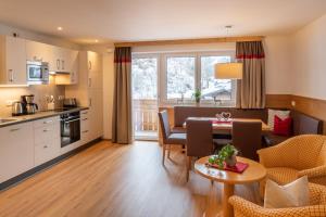a kitchen and a living room with a table and chairs at Appartement Schattauer in Wagrain