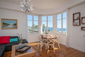 a living room with a table and chairs and windows at Le Panoramic, fantastic view! in Nice