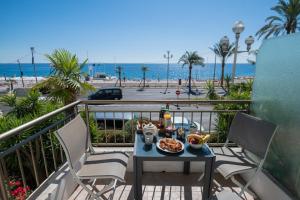 a table with food on a balcony with a view of the beach at Le Panoramic, fantastic view! in Nice