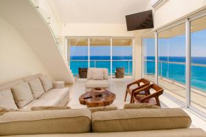 een woonkamer met een bank en een tafel bij 2 Story Oceanfront Penthouses on Cancun Beach! in Cancun