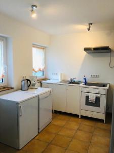 a kitchen with white cabinets and a stove top oven at Ferienhaus Jehle Friedrichshafen in Friedrichshafen