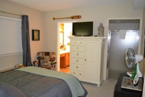 um quarto com uma cama e uma cómoda com uma televisão em River Place Condos #407 2BD em Pigeon Forge
