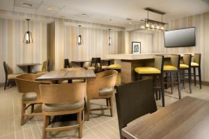 a restaurant with tables and chairs and a flat screen tv at Holiday Inn Express Boston North-Woburn, an IHG Hotel in Woburn