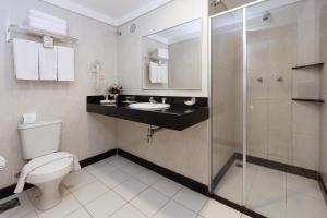a bathroom with a toilet and a sink and a shower at Hotel Bahia do Sol in Salvador +47 photos