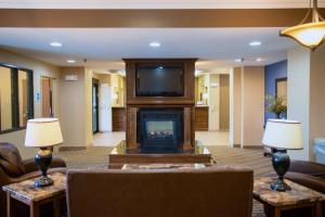 a living room with a fireplace and a tv at Holiday Inn Express Devils Lake, an IHG Hotel in Devils Lake