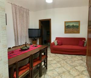 un soggiorno con un divano rosso e un tavolo di Casa Serena a Torino