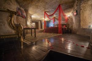 Habitación con cama y mesa con velas en el suelo en Kapadokya Ihlara Konaklari & Caves en Guzelyurt