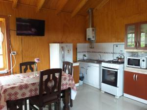 a kitchen with a table and a kitchen with white appliances at Villa Rosa House in Pinto