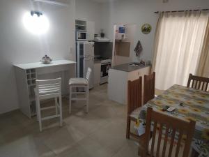 cocina y comedor con mesa y sillas en Alojamiento Vio Plaza Villa Elisa en Villa Elisa