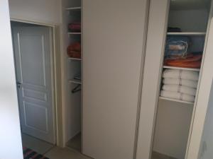 a closet with white walls and a door and towels at Alojamiento Vio Plaza Villa Elisa in Villa Elisa +3 photos