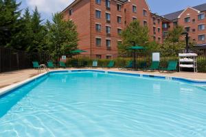 a large swimming pool with chairs and a building at Staybridge Suites Tysons - McLean, an IHG Hotel in McLean