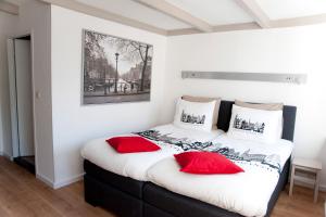 a bedroom with a large bed with red pillows at Residence Flower Market in Amsterdam