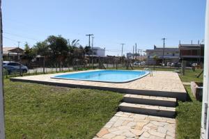 a swimming pool in the middle of a yard at Pousada ACM Tramandaí - RS in Tramandaí
