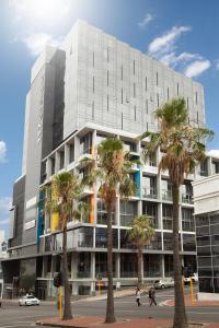 a building with palm trees in front of it at 117 on Strand - Luxury Apartments in Cape Town