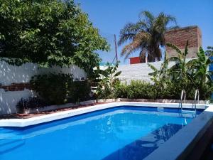 uma piscina em frente a um edifício com árvores em Amanitas Hotel em Villa Carlos Paz