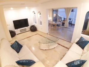 ein Wohnzimmer mit 2 weißen Sofas und einem TV in der Unterkunft LOS CRISTIANOS LUXURY SEA VIEW in Arona