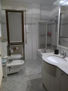 bagno con lavandino, vasca e servizi igienici di IL GIRASOLE a Tirano