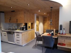 a kitchen and dining room with a table and chairs at Das Edelweiss in Grän