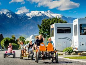 a group of children riding onicycles in front of a trailer at Kaikoura TOP 10 Holiday Park in Kaikoura