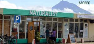 Menschen stehen vor einem Restaurant mit einem Berg im Hintergrund in der Unterkunft Casa do Porto da Horta in Horta + 3 Fotos
