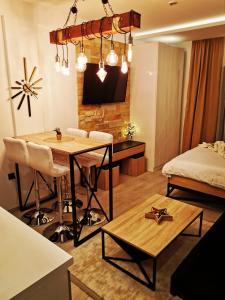 een woonkamer met een tafel en een bed bij Milmari boutique apartment S4 in Kopaonik