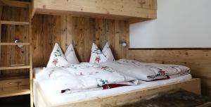 two beds in a room with wooden walls at Apartments Vaiolet in Santa Cristina in Val Gardena