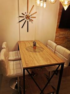 a dining room table with chairs and a clock on the wall at Milmari boutique apartment S4 in Kopaonik +41 photos