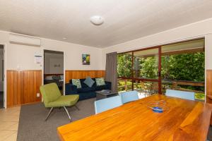 a living room with a wooden table and a couch at Blue Lake TOP 10 Holiday Park in Rotorua