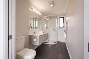 a white bathroom with a toilet and a sink at Seabrook Hotel in Somerset