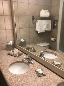 a hotel bathroom with two sinks and a mirror at Inn of the Hills Hotel and Conference Center in Kerrville