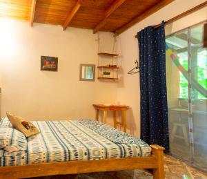 - une chambre avec un lit et une fenêtre dans l'établissement Colibri hostal Minca Santa Marta, à Minca
