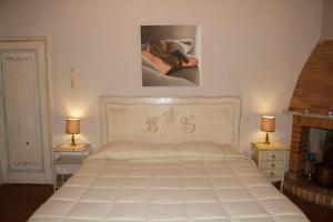 - un lit blanc dans une chambre avec deux lampes dans l'établissement Santa Croce Charme Apartment, à Arezzo
