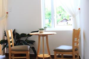 a small table and two chairs in front of a window at Selena Dalat Homestay Yersin in Da Lat