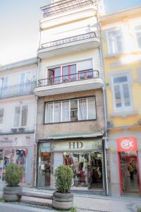 a tall building on a city street with a store at Travel & Live Porto Hostel in Porto