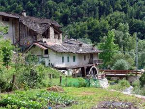 una casa vieja al lado de una colina en Rifugio Escursionistico La Ruà, en Macra