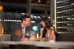 a man and a woman sitting at a table with wine glasses at Fairmont Waterfront in Vancouver