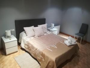 um quarto com uma cama grande e uma cadeira azul em Casa De Paz em Zamora