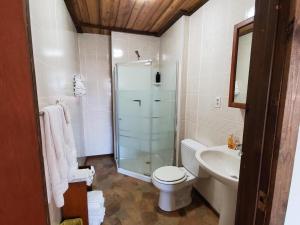 uma casa de banho com um chuveiro, um WC e um lavatório. em Little River Inn Motel em Leon