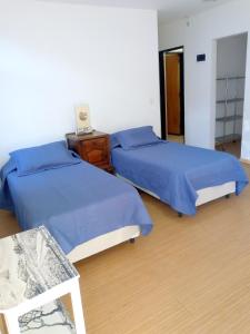 two beds in a room with blue sheets and a table at Garden Atelier Eco Friendly in La Cumbre +40 photos
