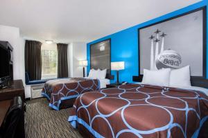 a hotel room with two beds and a flat screen tv at Super 8 by Wyndham Pensacola in Pensacola